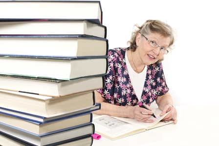 Woman Studying peering at a stack of books