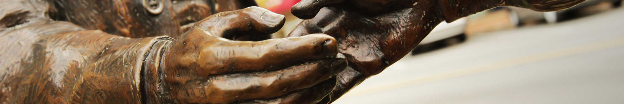 Metal statue located in downtown San Jose reaching to hold another hand.