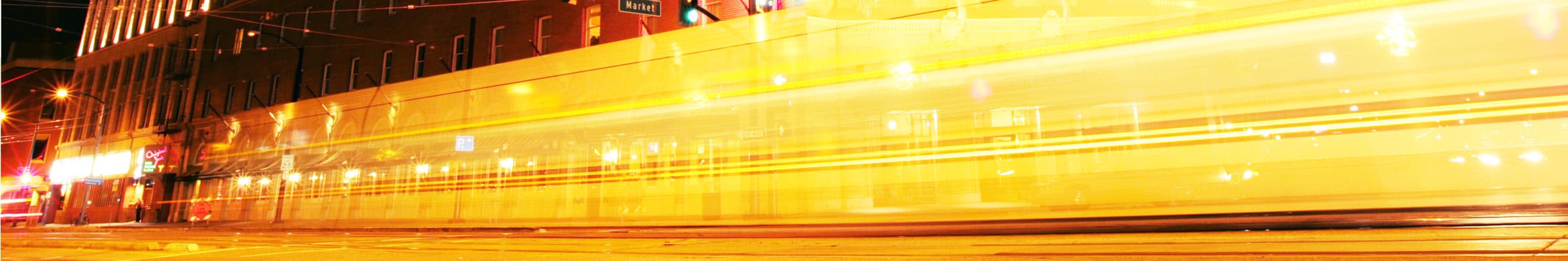 Front entrance of downtown San Jose's Westin hotel with VTA lightrail passing by at night.