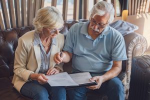 Senior couple checking into a hotel. Elderly couple sitting in a hotel lobby filling in forms